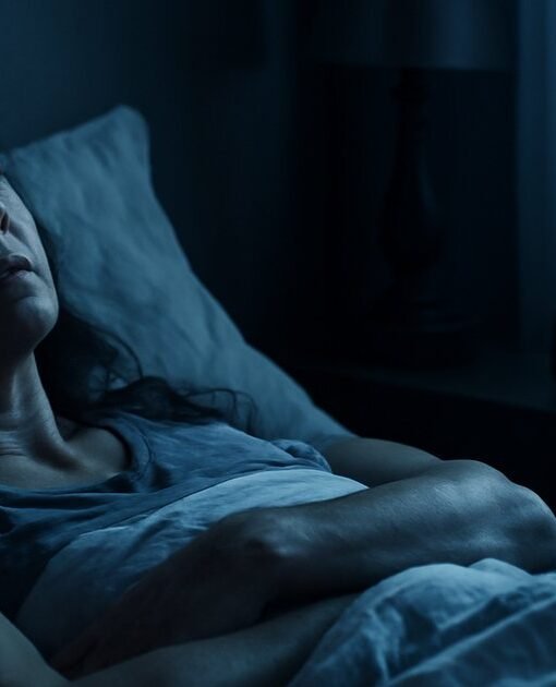 Woman lying awake at night with anxious expression, unable to sleep due to anxiety